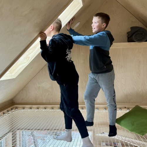 Wohnnetz LOFTNETS unter Velux mit 2 Kindern stehend
