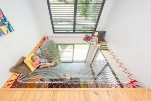 A playroom with suspended net and red rope 