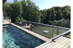 Grand filet bain de soleil en bordure de piscine en surplomb du jardin